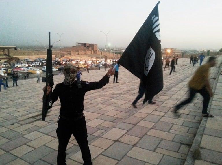 <p>A fighter of the Islamic State of Iraq and the Levant (ISIL) holds an ISIL flag and a weapon on a street in the city of Mosul, June 23, 2014. U.S. Secretary of State John Kerry held crisis talks with leaders of Iraq&#8217;s autonomous Kurdish region on Tuesday urging them to stand with Baghdad in the face of a Sunni insurgent onslaught that threatens to dismember the country. Picture taken June 23, 2014. REUTERS/Stringer (IRAQ &#8211; Tags: CIVIL UNREST POLITICS TPX IMAGES OF THE DAY) &#8211; RTR3VIB1<br />
CREDIT: Reuters</p>
