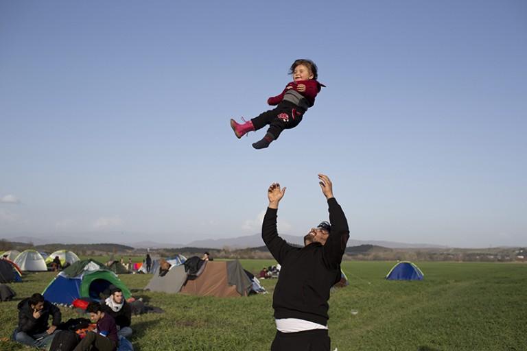 <p>A Syrian man plays with his one-year child as refugees and migrants wait to be allowed to cross the border to Macedonia in the northern Greek border station of Idomeni on, Tuesday, March, 1 2016. Some 7,000 migrants, including many from Syria and Iraq, are crammed into a tiny camp at the Greek border village of Idomeni, and hundreds more are arriving daily. (Petros Giannakouris/AP)</p>
