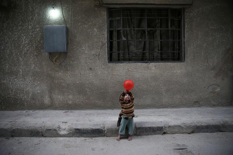 <p>A child plays with a balloon in the rebel-held besieged city of Douma, in the eastern Damascus suburb of Ghouta, Syria November 13, 2016. (Bassam Khabieh/Reuters)</p>
