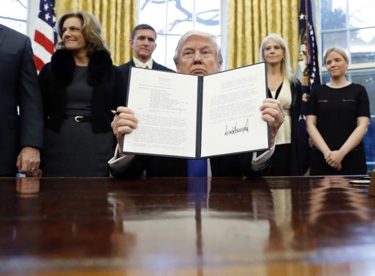 <p>President Donald Trump holds up a signed Presidential Memorandum in the Oval Office in Washington. The document directs his administration to &#8220;develop a comprehensive plan to defeat ISIS.&#8221; (AP Photo/Alex Brandon)</p>
