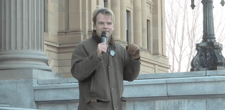 <p>Chris Alexander, on the steps of the Alberta legislature for a Rally for Alberta held by Rebel Media. (Screen capture)</p>
