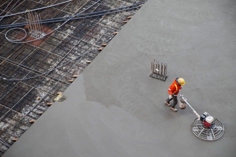 A worker is seen smoothing concrete at a development prior to a news conference at a construction site in Toronto on Jan. 16, 2020. (Cole Burston/CP)