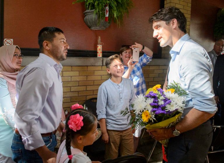 Canadian Prime Minister Justin Trudeau greets the Azimi family, who are refugees from Afghanistan after fleeing Syria, at the Old South Village Pub before having a meal in London, Ont. on Jul. 4, 2019. The Azimi family has been in Canada for 15 months. Refugees are among the highly vulnerable during the coronavirus pandemic. (Andrew Lahodynskyj/CP)