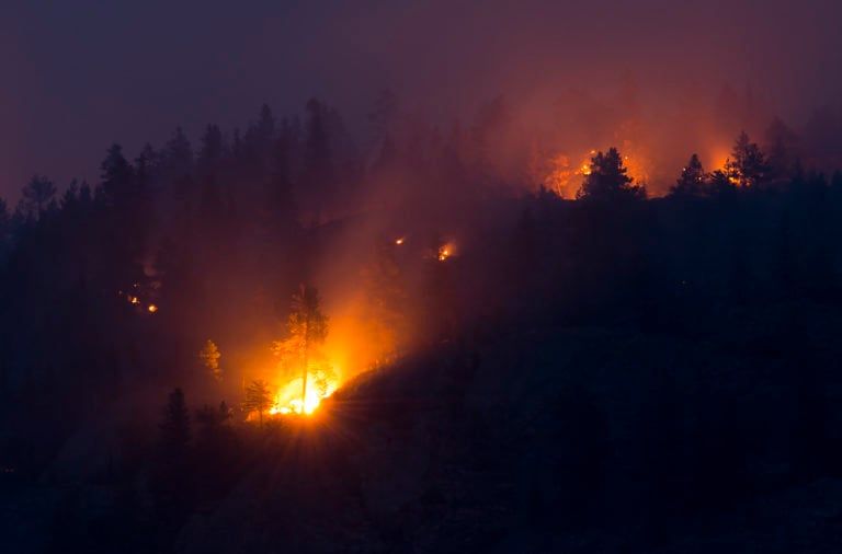 Flareups are seen from the Christie Mountain wildfire along Skaha Lake in Penticton, B.C. on August 20, 2020. (Jonathan Hayward/CP)