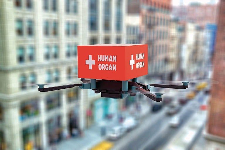 Delivery drone flying in city with human organ transplant material. (Baran Ozdemir/iStock)