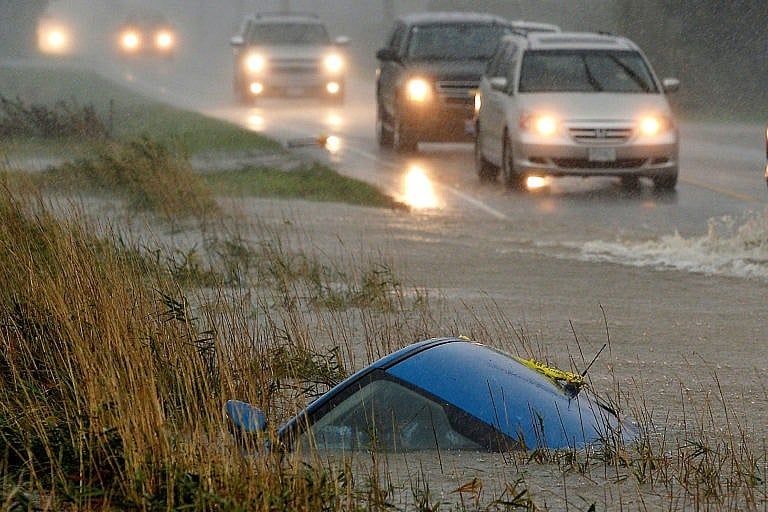 A car lies submerged in a ditch on a flooded stretch of road after rainstorms lashed the western Canadian province of British Columbia, triggering landslides and floods, shutting highways, in Chilliwack, British Columbia, Canada November 15, 2021. (Jennifer Gauthier/Reuters)
