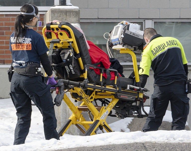 Ambulance workers IN Montreal transport a patient to the emergency room as hospitalizations continue to rise due to the COVID-19 pandemic. Jan. 5, 2022 in Montreal. (Ryan Remiorz/The Canadian Press)