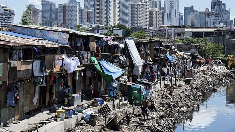 People living in a settlement walk about, as the skyline of Manila's financial district is seen in the background, on August 17, 2017. The Philippine economy grew by 6.5 percent in the three months to June, likely one of the fastest in Asia, the government said on August 17, defying concerns over President Rodrigo Duterte's unconventional leadership. (Noel Celis/AFP/Getty Images)