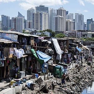 People living in a settlement walk about, as the skyline of Manila's financial district is seen in the background, on August 17, 2017. The Philippine economy grew by 6.5 percent in the three months to June, likely one of the fastest in Asia, the government said on August 17, defying concerns over President Rodrigo Duterte's unconventional leadership. (Noel Celis/AFP/Getty Images)