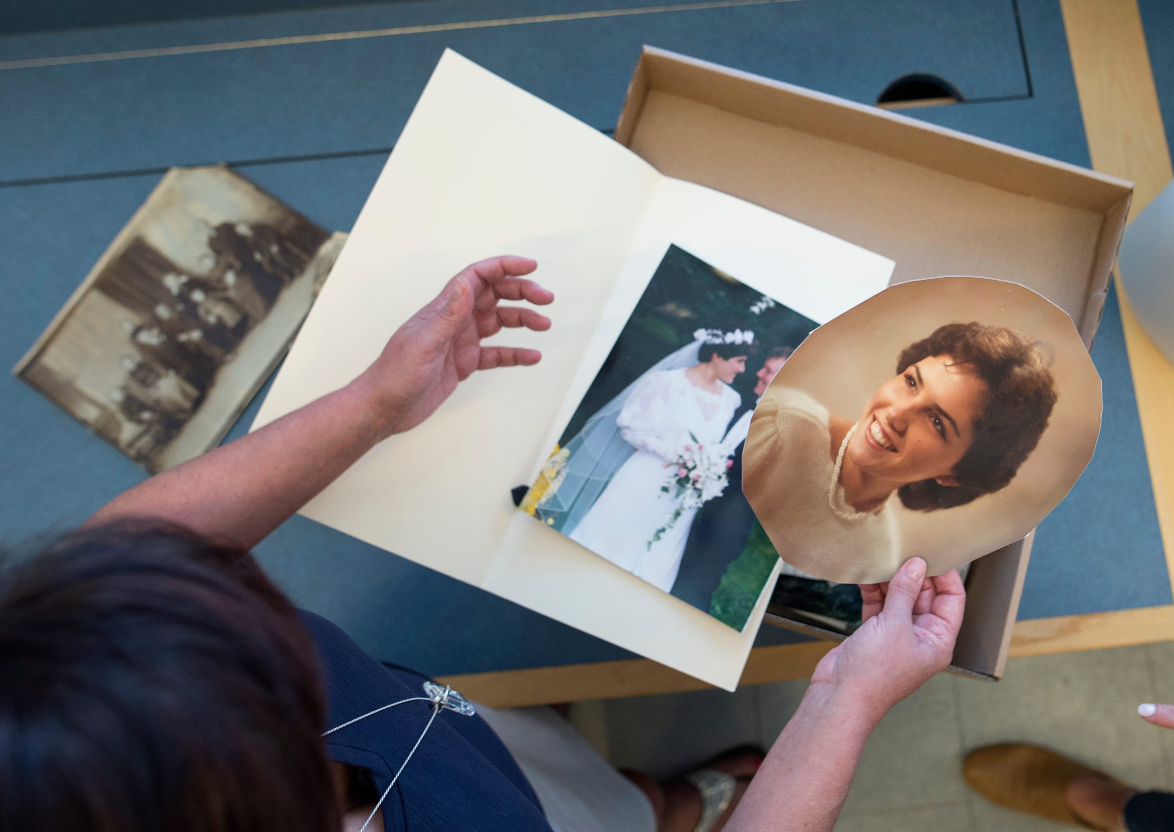 Alana Gorman holds one of her wedding photos as she goes through recovered family photos damaged in the flood at the Provincial Archives of New Brunswick in Fredericton, N.B. on Thursday, May 24, 2018. (Photograph by Darren Calabrese)