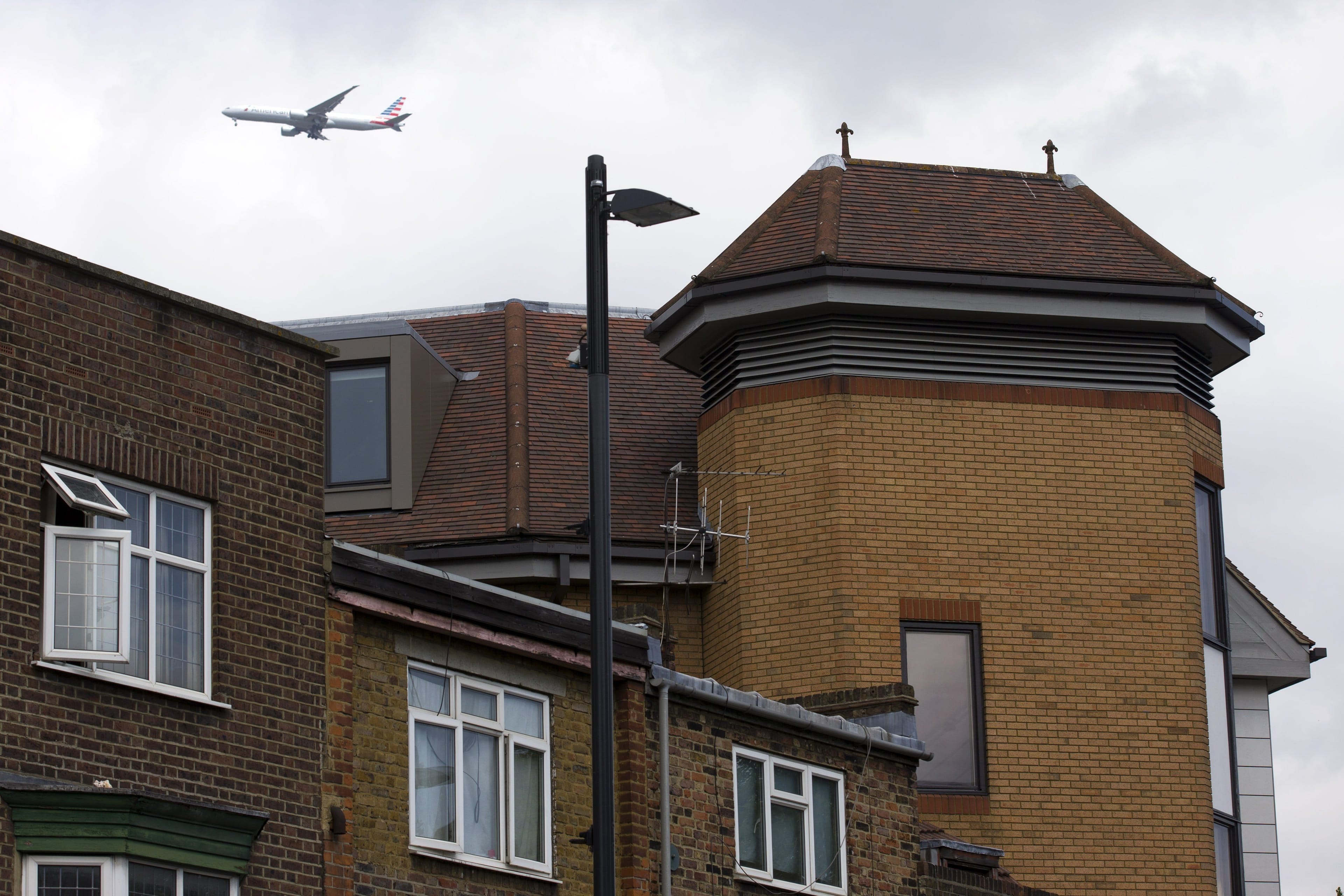 A airplane flies on June 19, 2015, over a building in Richmond where the body of a dead man was found on the roof.
(Justin Tallis/AFP/Getty Images)