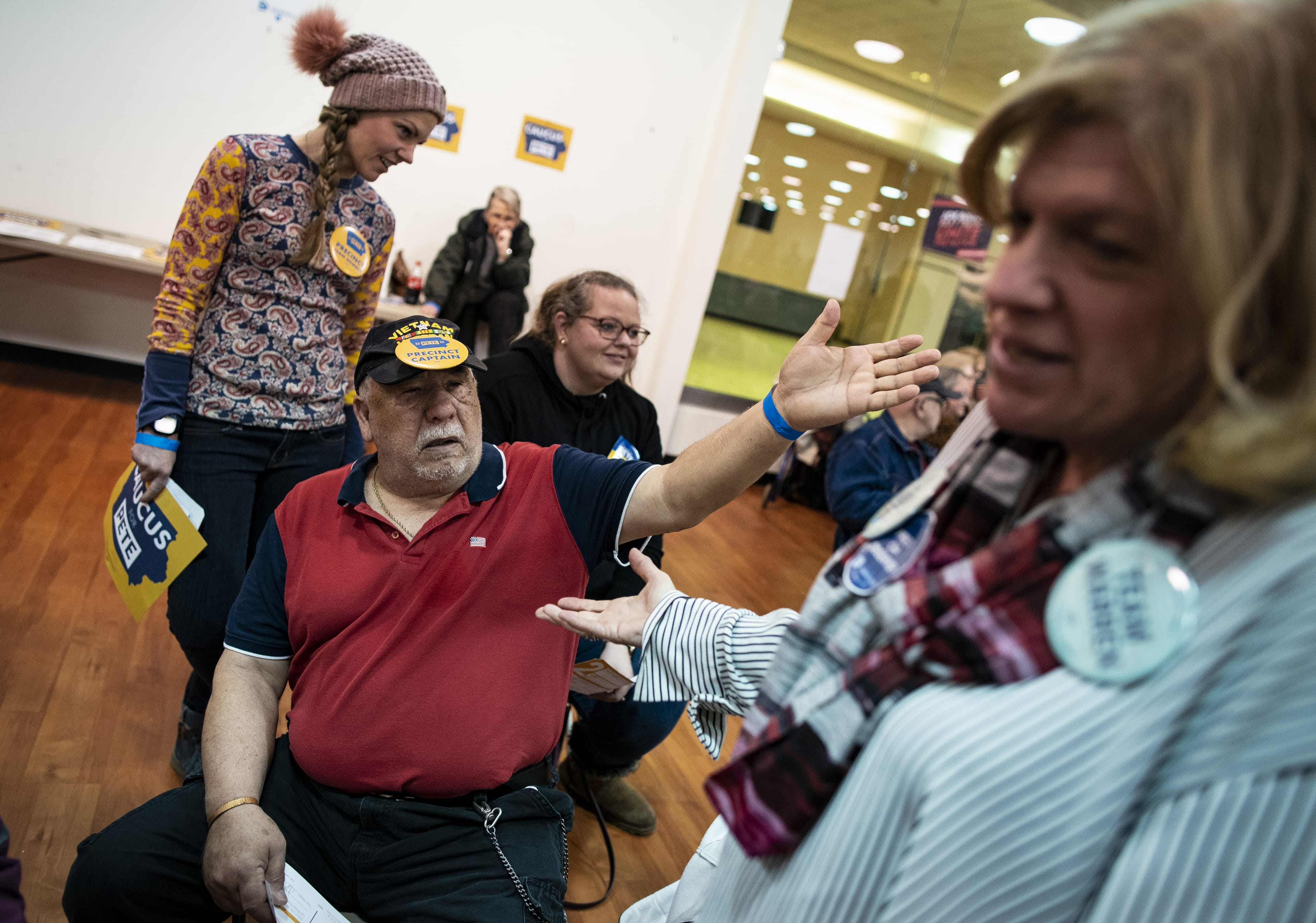 A supporter of Pete Buttigieg speaks with a supporter of Elizabeth Warren during the Iowa caucus at the Southridge Mall in Des Moines, Iowa, on Feb. 3, 2020. (Al Drago/Bloomberg/Getty Images)