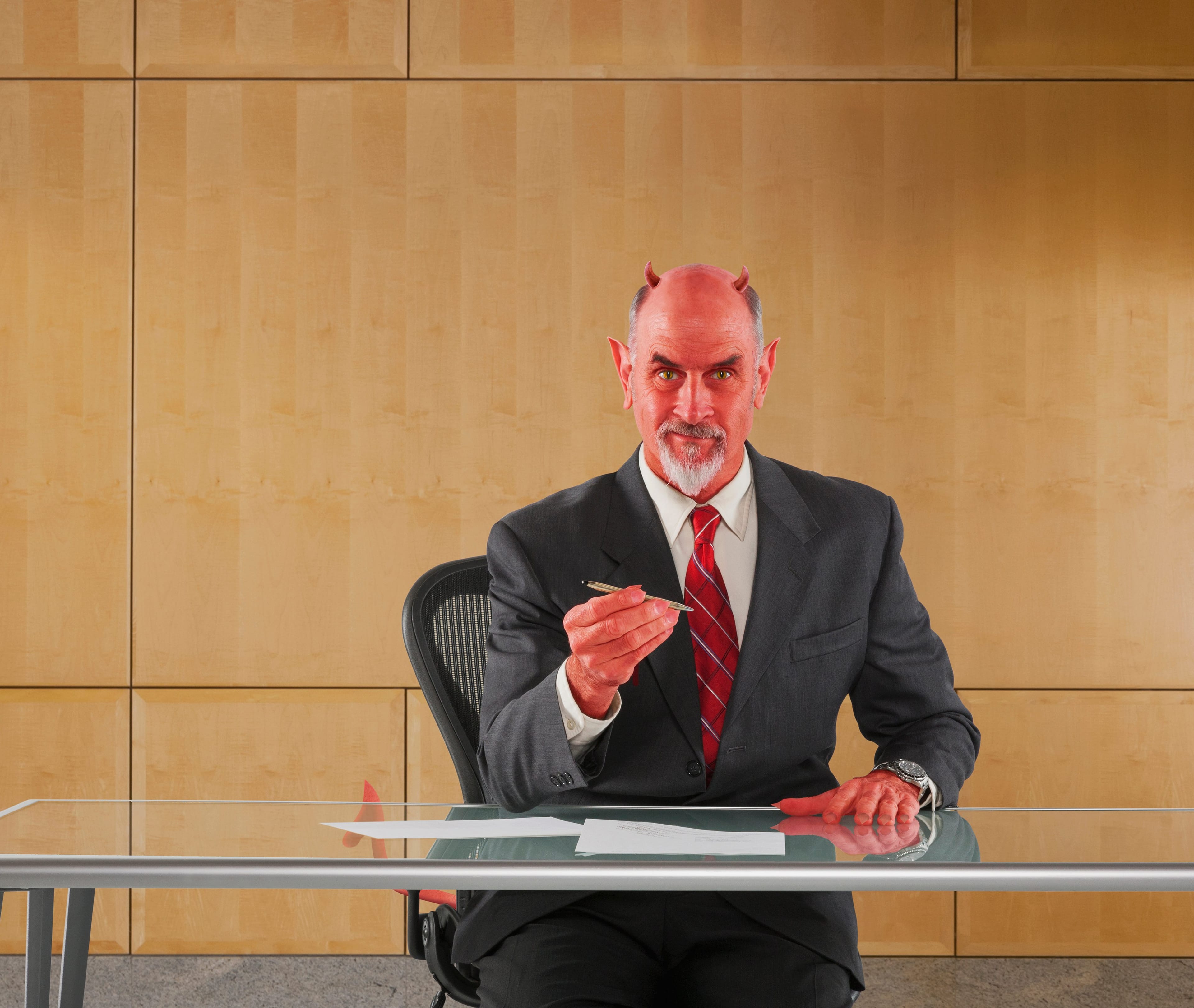 Caucasian businessman in devil costume offering pen to sign contract(John Lund/Getty Images)