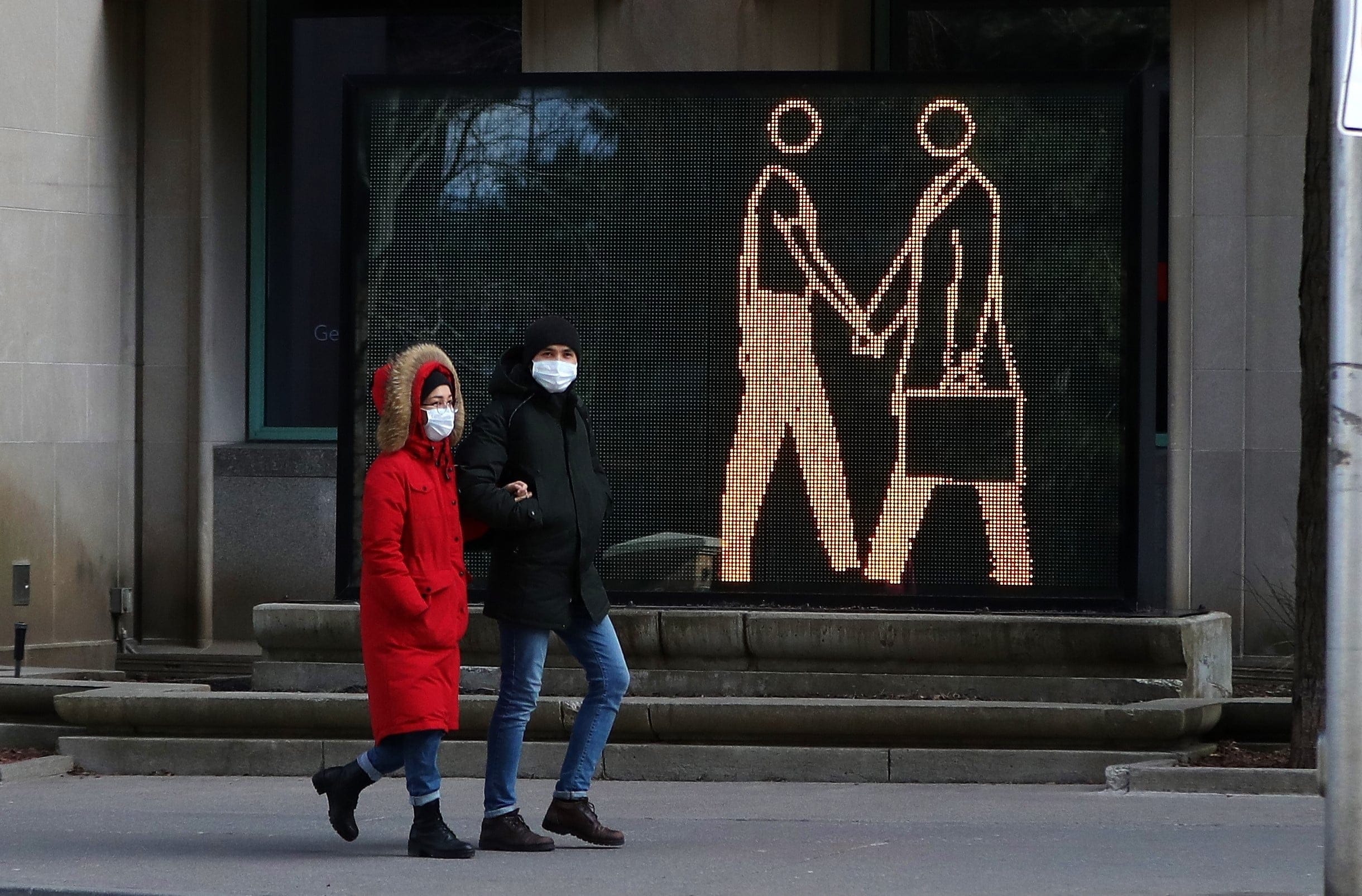 A couple walks on Toronto's Bloor Street on April 10, 2020 (CP/Colin Perkel)