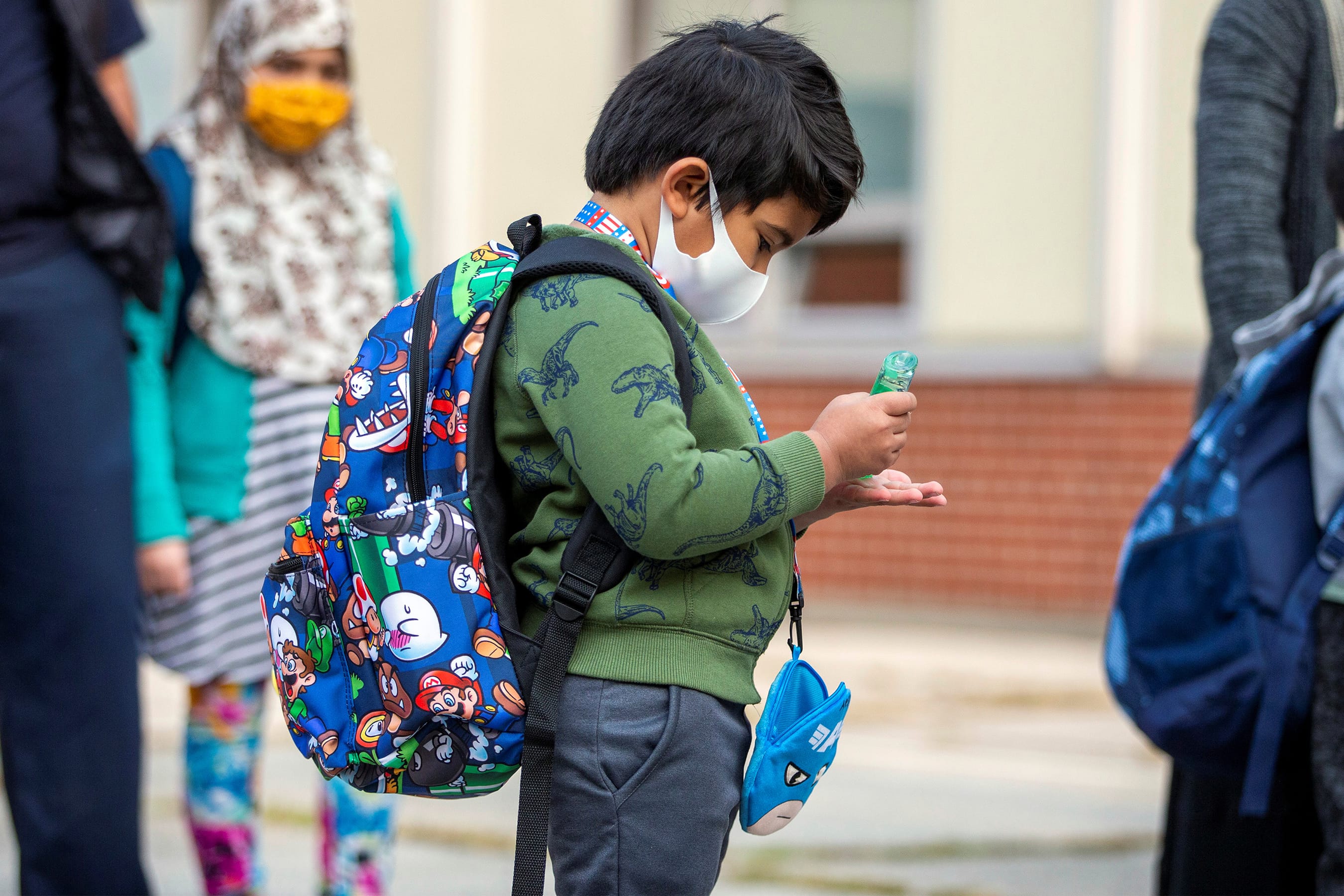 A student uses hand sanitizer as he arrives at school in September 2020 (Carlos Osorio/Reuters)