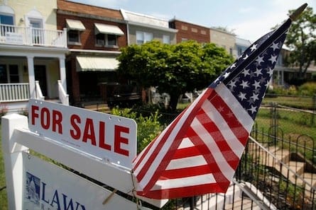 A U.S. flag decorates a for-sale sign at a home in the Capitol Hill neighborhood of Washington