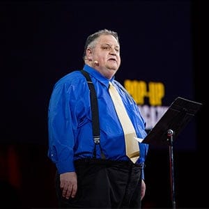 Steve Silberman delivers a speech at a Ted Talk. Still from YouTube