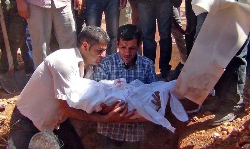 epa04912276 Abdullah al-Kurdi (C), father of the drowned three-year-old boy Aylan Kurdi from Syria, holds his son's body as they burry drowned migrants during a funeral in Kobane, Syria, 04 September 2015. Pictures of the boy's body washed ashore in Turkey appeared on 02 September after his family tried to escape the conflict in Syria. His mother, Rehan, and 5-year-old brother, Galip, also died. Pictures of Alan (also spelled Aylan) lying face down in a shallow pool of water where he was found by Turkish police caused outrage around the world and led to an outpouring of sympathy for Syrian refugees. (DICLE NEWS AGENCY/EPA/CP)