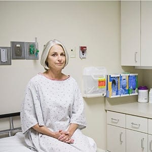 Senior female patient sitting on examination table, portrait. (Andersen Ross/Getty Images)