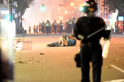 Riot police walk in the street as a couple kisses on June 15, 2011 in Vancouver, Canada. Vancouver broke out in riots after their hockey team the Vancouver Canucks lost in Game Seven of the Stanley Cup Finals. (Rich Lam/Getty Images)