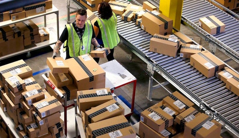 FILE - In this Monday, Dec. 2, 2013, file photo, Amazon.com employees organize outbound packages at an Amazon.com Fulfillment Center on "Cyber Monday" the busiest online shopping day of the holiday season in Phoenix. Amazon announced Wednesday, March 9, 2016, it has finalized an agreement to lease 20 Boeing jets from Air Transport Services Group as it builds out its delivery capabilities. (AP Photo/Ross D. Franklin, File)