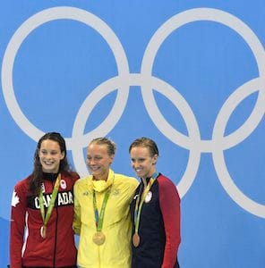 Sweden's gold medal winner Sarah Sjostrom is flanked by Canada's silver medal winner Penny Oleksiakand, left, and United States' bronze medal winner Dana Vollmer during the medal ceremony for the women's 100-meter butterfly final at the swimming competitions at the 2016 Summer Olympics, Sunday, Aug. 7, 2016, in Rio de Janeiro, Brazil. (AP Photo/Martin Meissner)