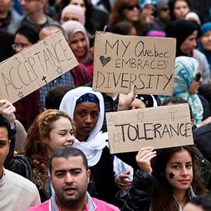 Demonstrators hold signs as they protest against Quebec's proposed Charter of Values in Montreal, September 14, 2013. Thousands took to the streets to denounce the province's proposed bill to ban the wearing of any overt religious garb by government paid employees. (Christinne Muschi/Reuters)