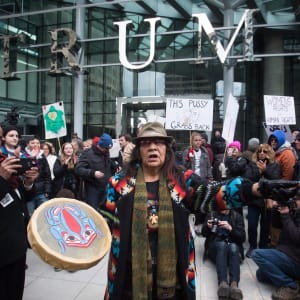 Viviane Sandy, of Williams Lake, B.C., plays a drum outside the official opening of the Trump International Hotel and Tower in Vancouver, B.C., on Tuesday February 28, 2017. U.S. President Donald Trump's sons Donald Jr. and Eric attended the opening. (Darryl Dyck/CP)