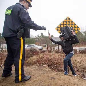 An RCMP officer warns a man to cross at the legal border crossing or he will be arrested at the border from New York into Canada on Wednesday, March 8, 2017 in Hemmingford, Quebec. (THE CANADIAN PRESS/Ryan Remiorz)