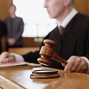 Judge holding gavel in courtroom. (OJO Images/Rex Features/Getty Images)