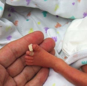 father holding his son little feet