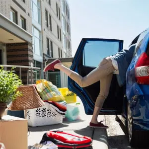 College student reaching in car moving into dorm. (Hero Images/Getty Images)