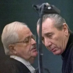 Vito Rizzuto (right) reputed head of the Montreal Mafia, speaks with his attorney Jean Salois after his hearing in Montreal Friday, Feb. 6, 2004. Rizzuto faces extradition to the United States to face charges related to the murders of three Mafia captains in New York in 1981. (CP PHOTO/Ryan Remiorz)