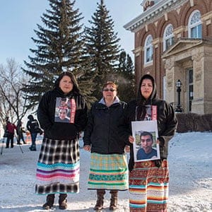 Krissa Baptiste, right, holds a picture of her cousin of Colten Boushie, as she leaves during a lunch recess on the day of closing arguments in the trial of Gerald Stanley, the farmer accused of killing 22-year-old Indigenous man Colten Boushie, in Battleford, Sask. on Thursday, February 8, 2018. THE CANADIAN PRESS/Liam Richards