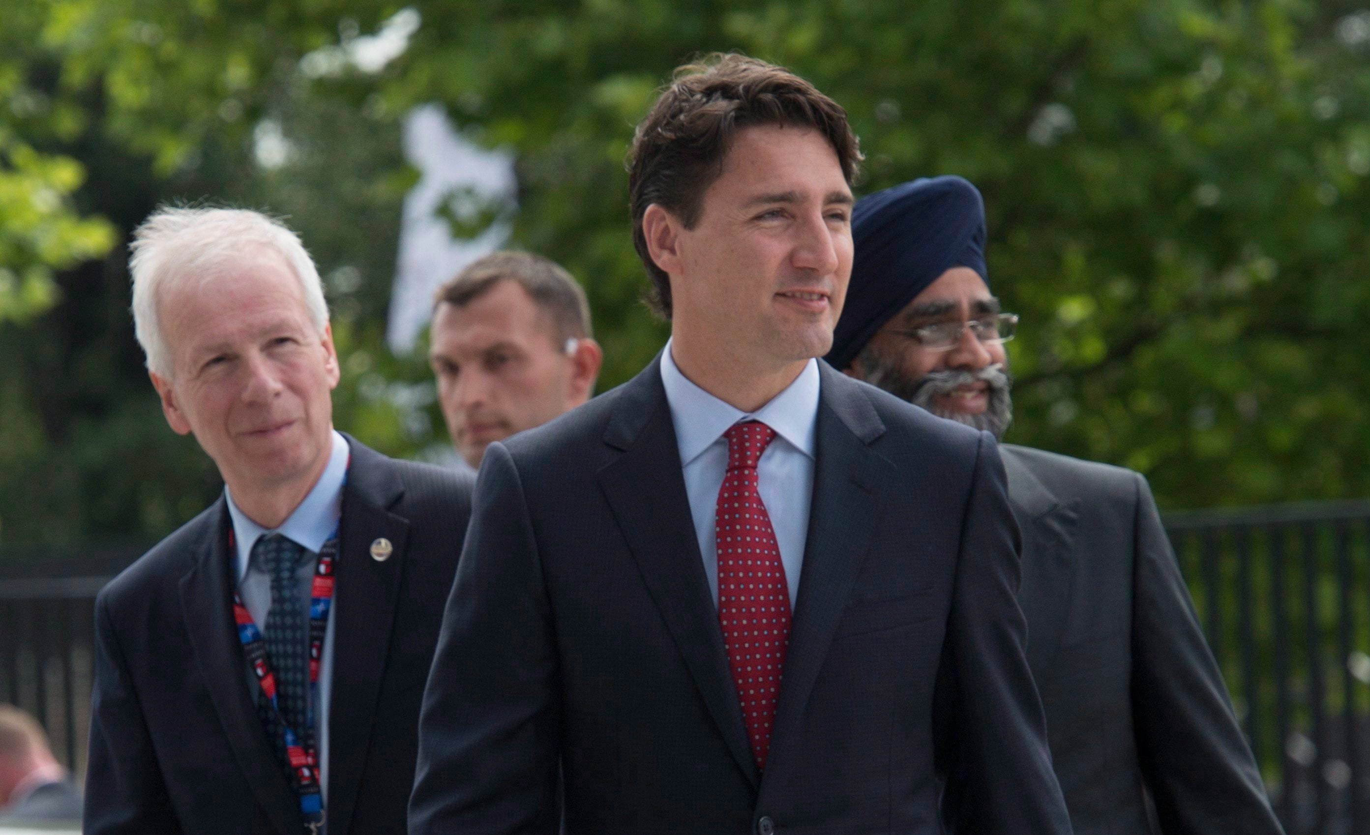 Canadian Prime Minister Justin Trudeau arrives with Foreign Affairs Minister Stephane Dion and Minister of National Defence Minister Harjit Sajjan at the NATO summit in Warsaw, Friday July 8, 2016. (THE CANADIAN PRESS/Adrian Wyld)