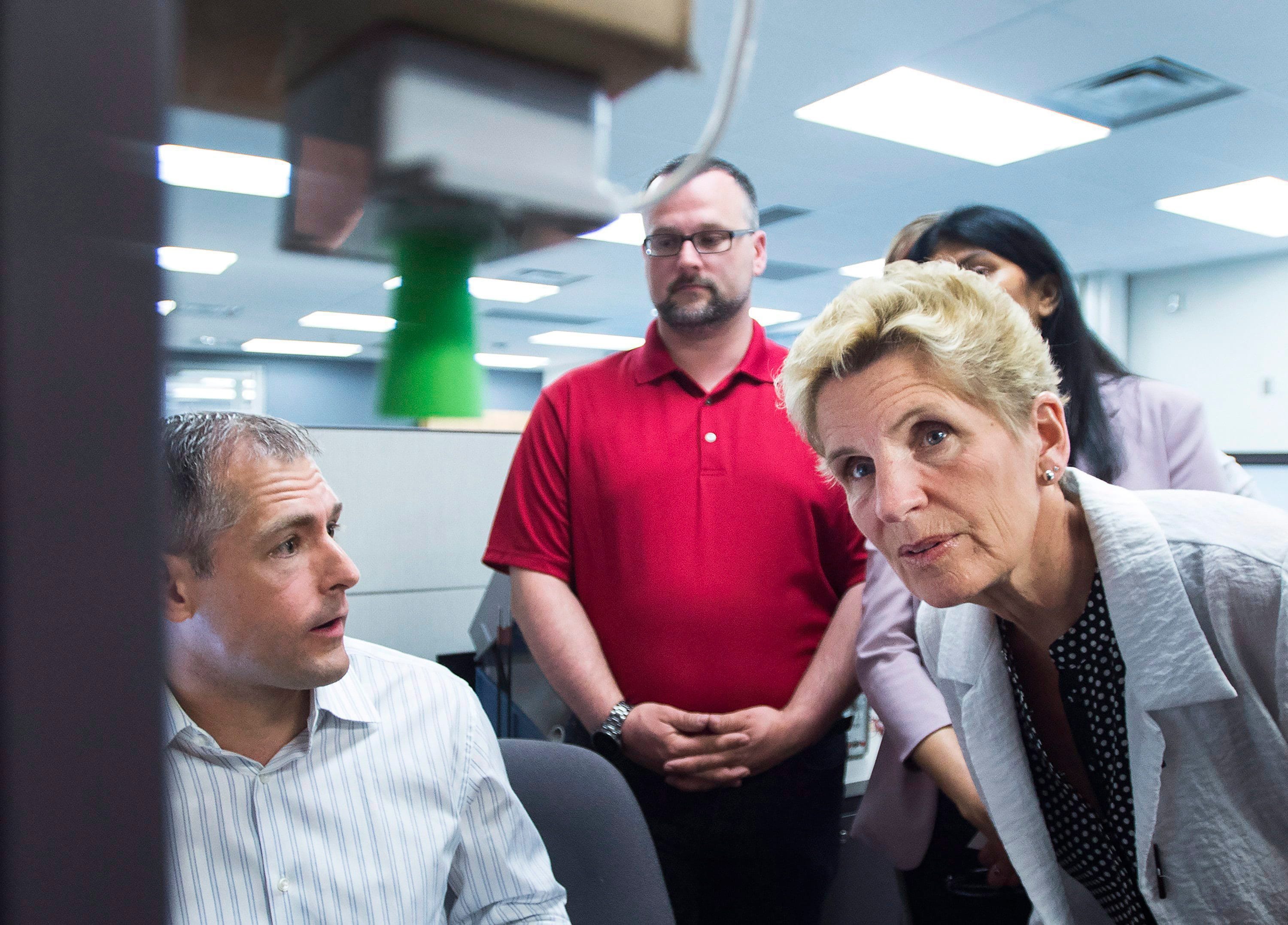 Ontario Liberal leader Kathleen Wynne looks at a sensor at eleven-x during a campaign stop in Waterloo, Ont., on Tuesday, May 15, 2018. (THE CANADIAN PRESS/Nathan Denette)