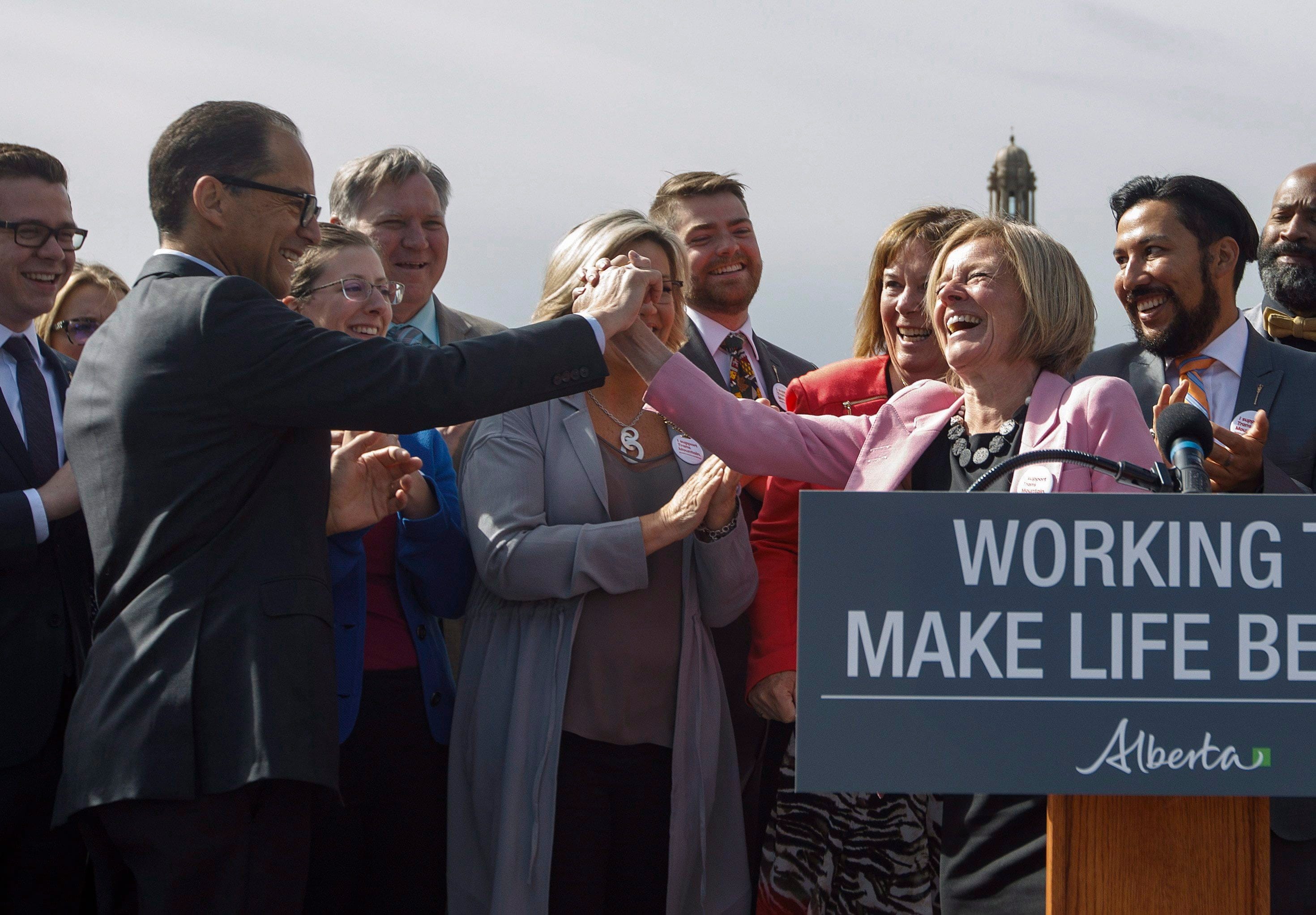 Alberta Premier Rachel Notley high fives Finance Minister Joe Ceci at a press conference to speak about the Kinder Morgan pipeline project, in Edmonton on Tuesday, May 29, 2018.THE CANADIAN PRESS/Jason Franson