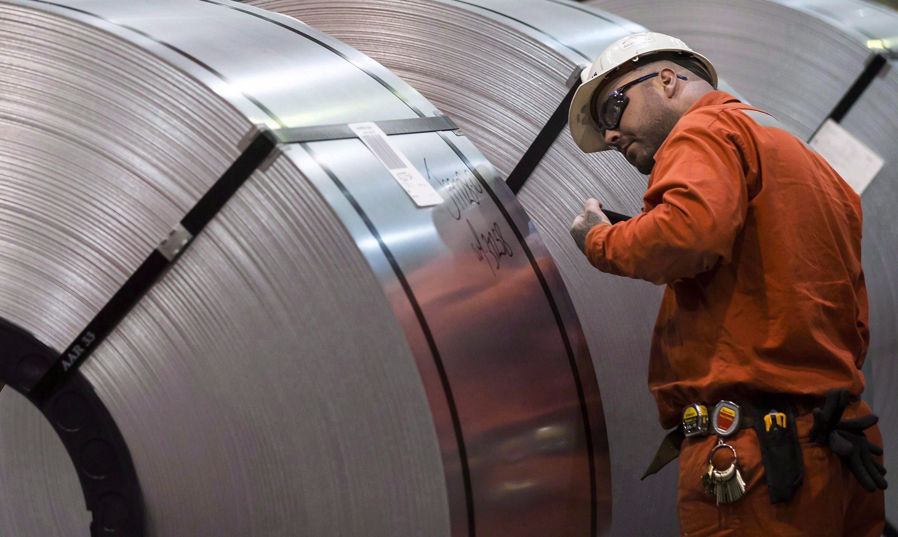 A Dofasco employee looks at rolls of coiled steel in Hamilton Ont., Tuesday, March 13, 2018. (THE CANADIAN PRESS/Tara Walton)