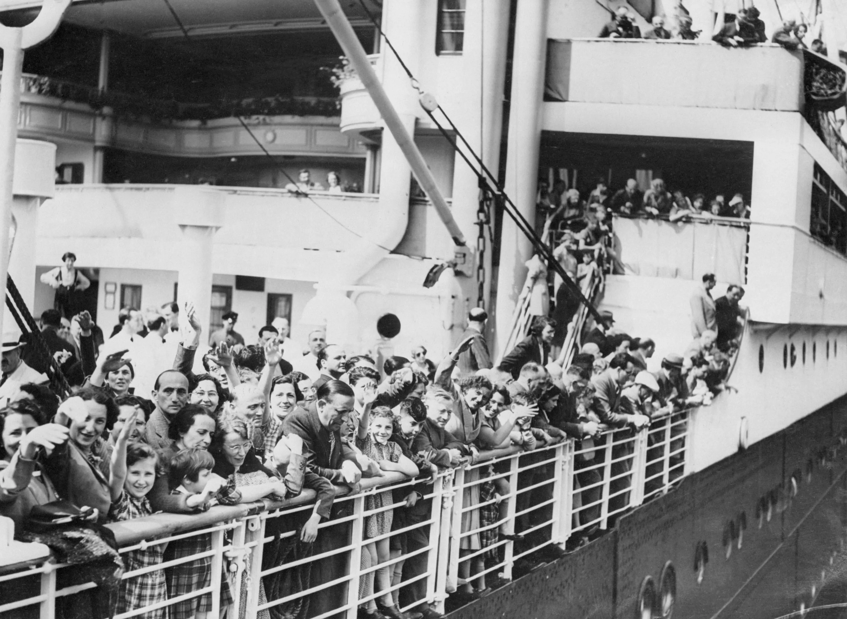 A crowd of German-Jewish refugees aboard the MS St. Louis ocean liner wave as they arrive in Antwerp, Belgium, after wandering the Atlantic for thousands of miles. The boat was denied entry when it reached the port of Havana, Cuba, even though passengers held documents permitting them to enter the country. (Getty Images)