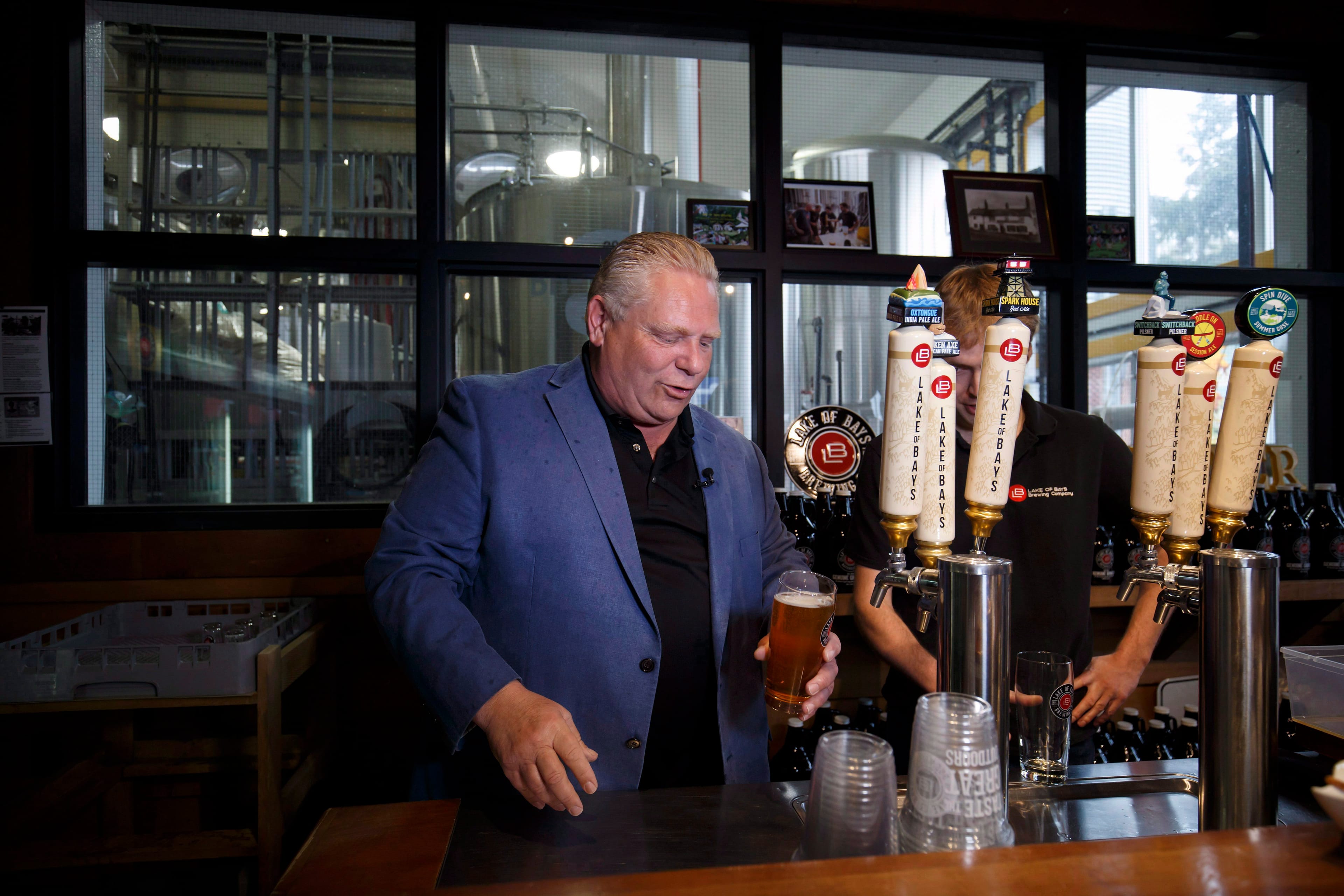 Ontario Progressive Conservative Leader Doug Ford pours beer from a tap at Lake of Bays Brewing Company in Baysville, Ont., on Saturday, May 19, 2018. THE CANADIAN PRESS/Cole Burston