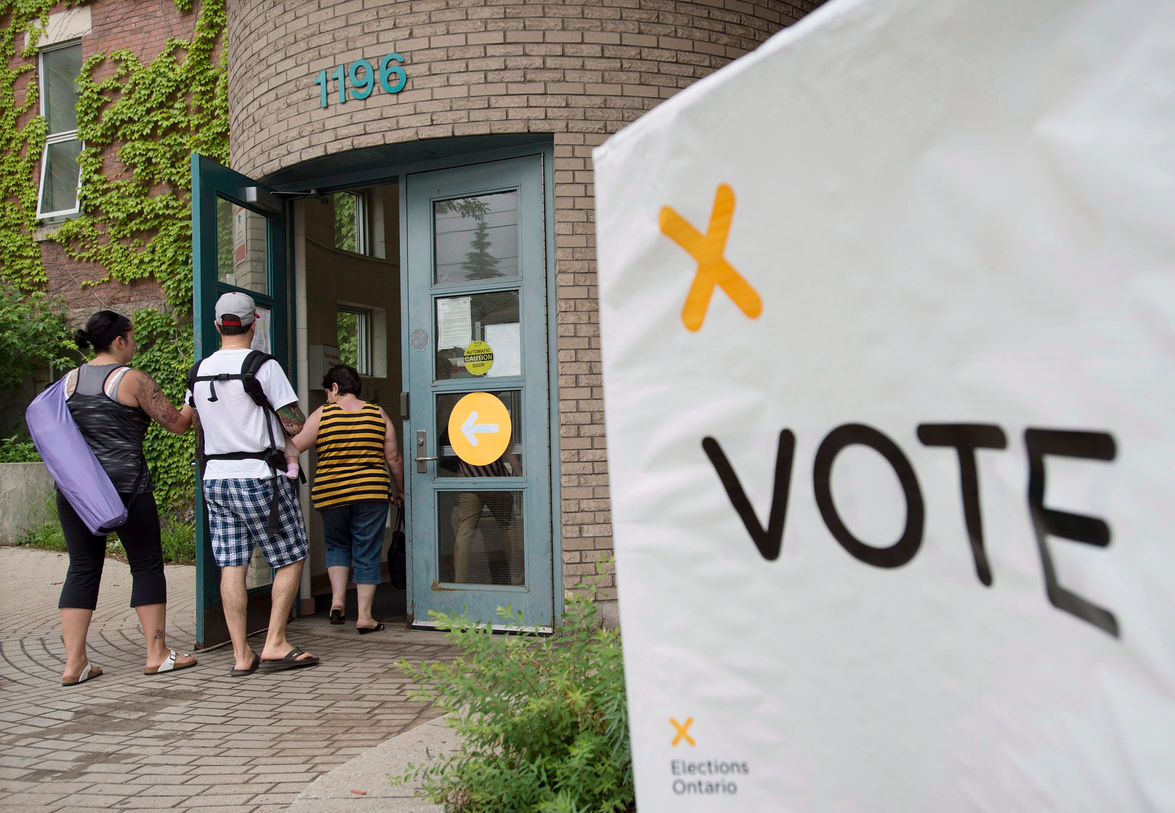 Voters arrive at a polling station in Toronto to cast their vote for the Ontario provincial election on Thursday, June 12, 2014. THE CANADIAN PRESS/Darren Calabrese