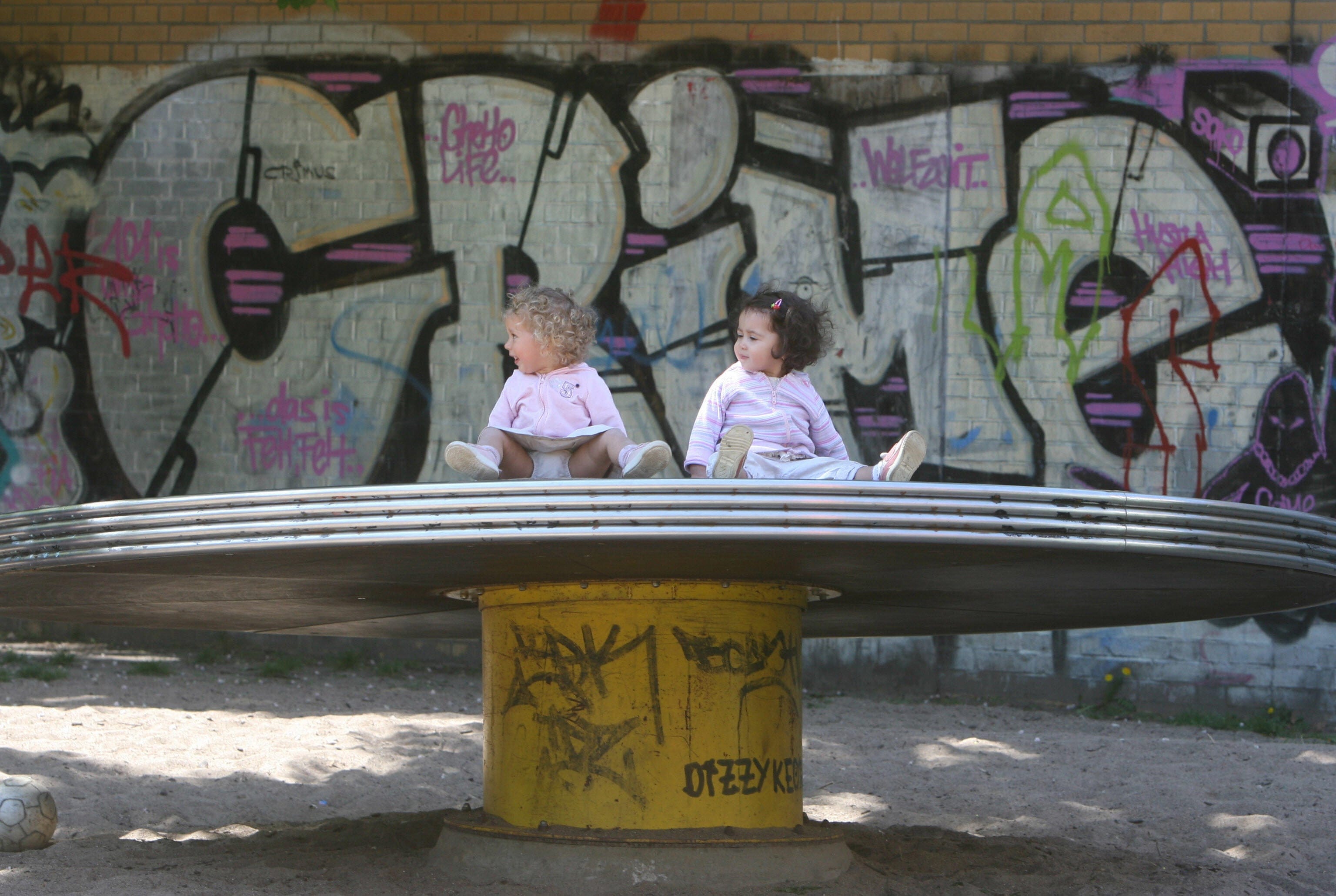 Toddlers Emma (R) and Marina play in a Berlin, Germany, playground on 26 April 2007. (JOHN MACDOUGALL/AFP/Getty Images)