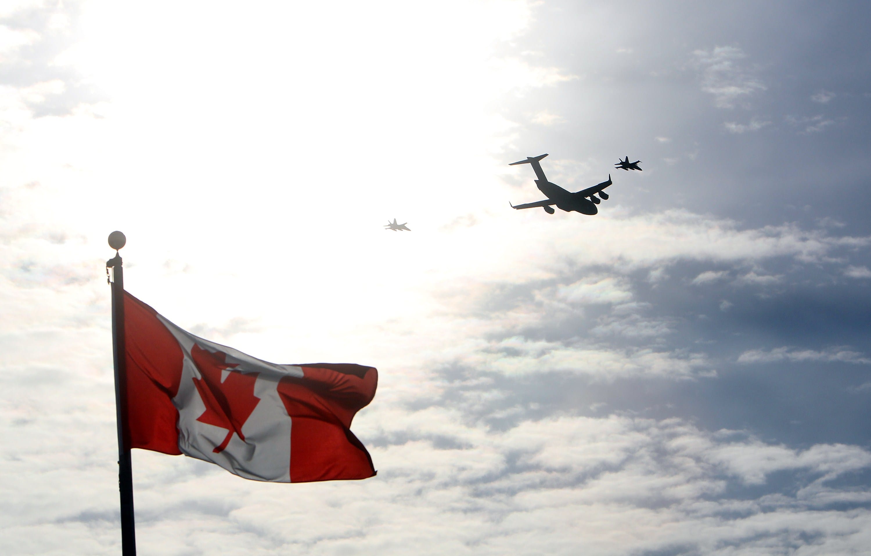 The plane carrying the last of Canada's troops in Afghanistan is escorted through the air by fighter jets, after the last Canadian troops from Afghanistan returned to Ottawa International Airport on March 18, 2014 in Ottawa, Ontario. (Cole Burston/AFP/Getty Images)