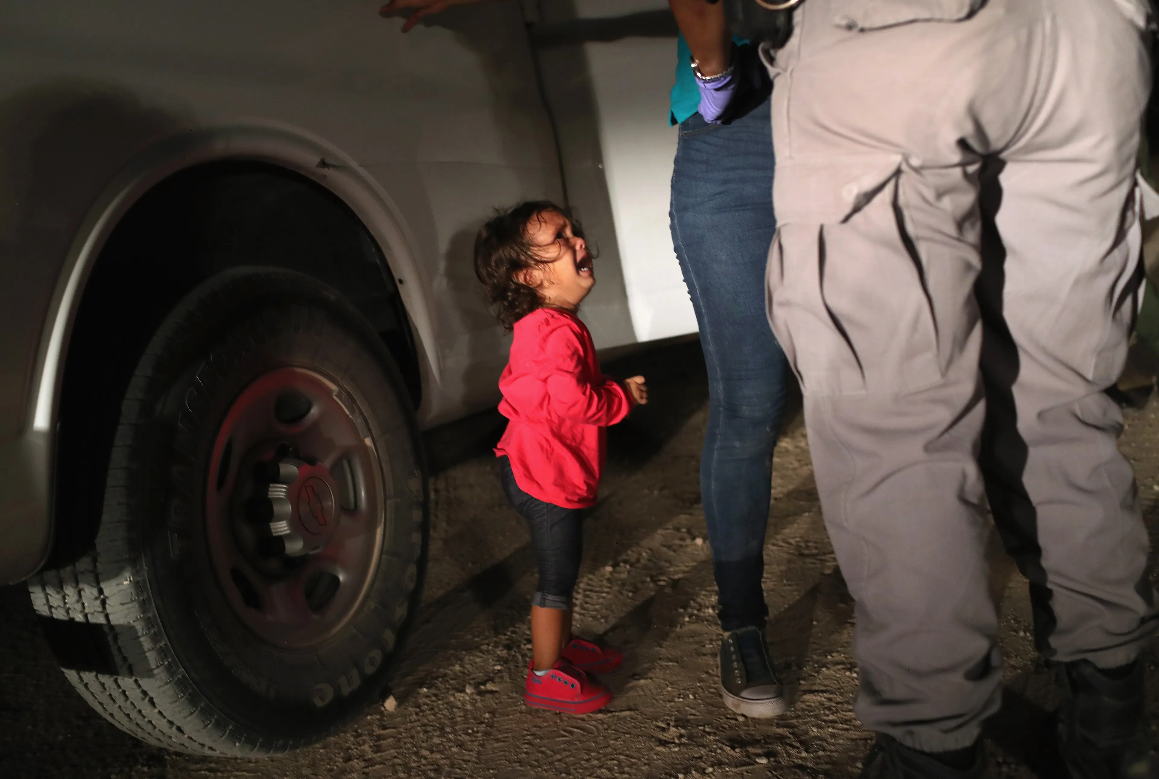 A two-year-old Honduran asylum seeker cries as her mother is searched and detained near the U.S.-Mexico border on June 12, 2018 in McAllen, Texas. The asylum seekers had rafted across the Rio Grande from Mexico and were detained by U.S. Border Patrol agents before being sent to a processing center for possible separation. (John Moore/Getty Images)