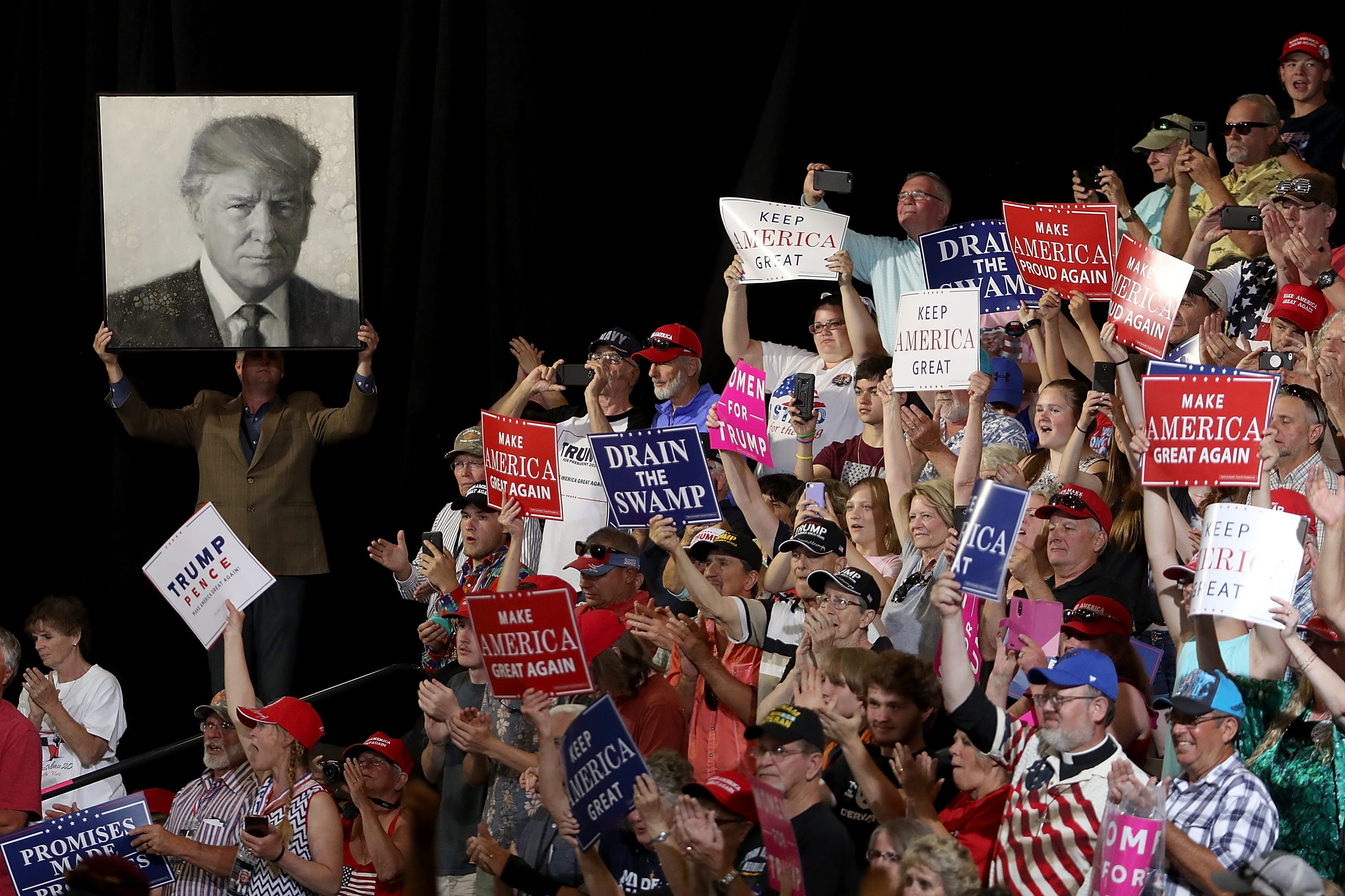 Supporters of U.S. president Donald Trump hold signs during a campaign rally at Four Seasons Arena on July 5, 2018 in Great Falls, Montana. (Justin Sullivan/Getty Images)