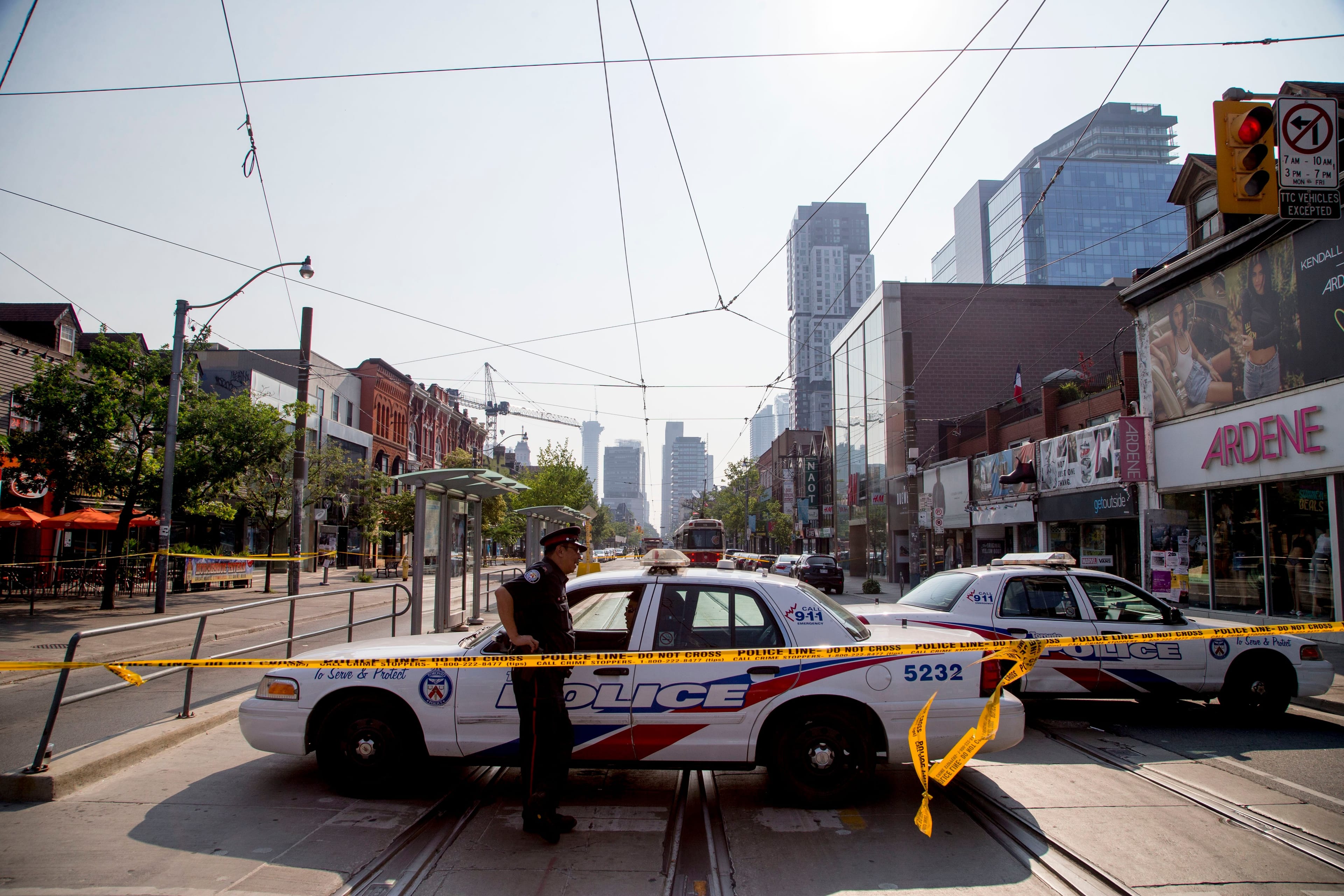Toronto police walk along Queen Street West on July 1, the morning after a shooting the previous night. (Carlos Osorio/Toronto Star/Getty Images)