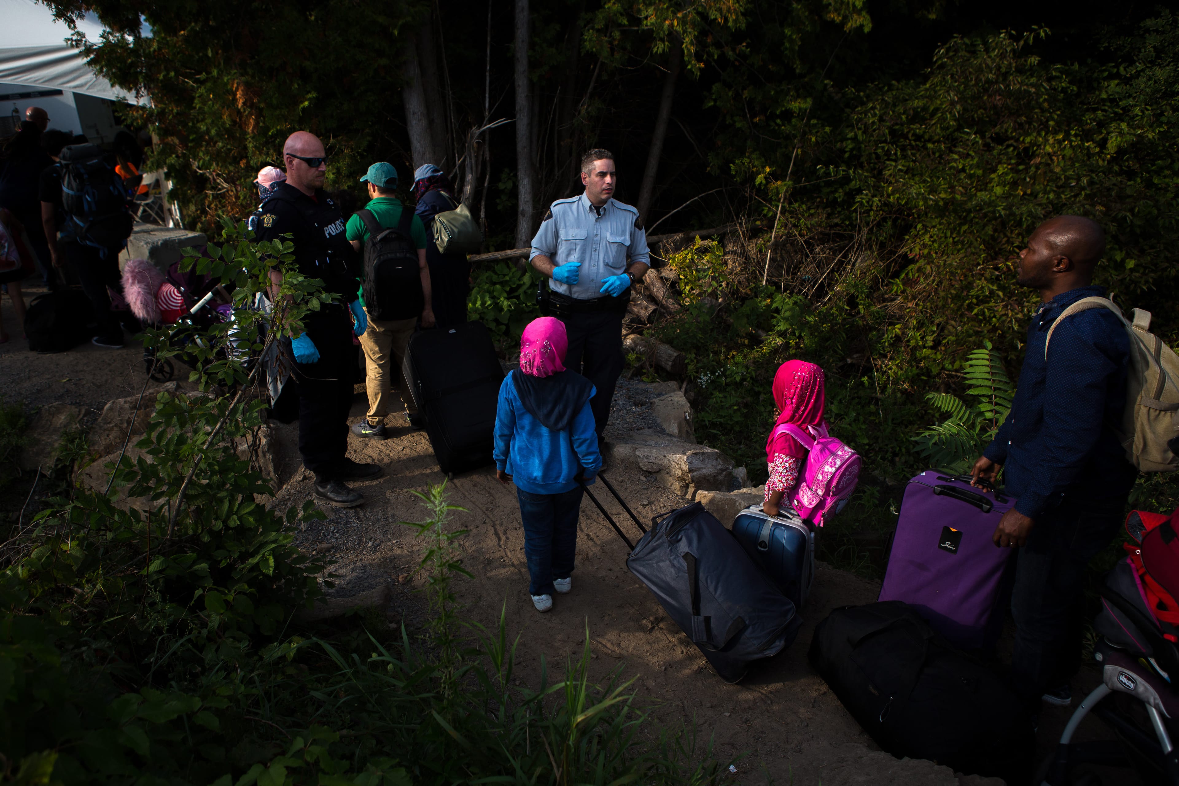 A family of four originally from Nigeria walk across the border at Roxham Road near Lacolle, QC in September, 2017. (Chris Donovan)