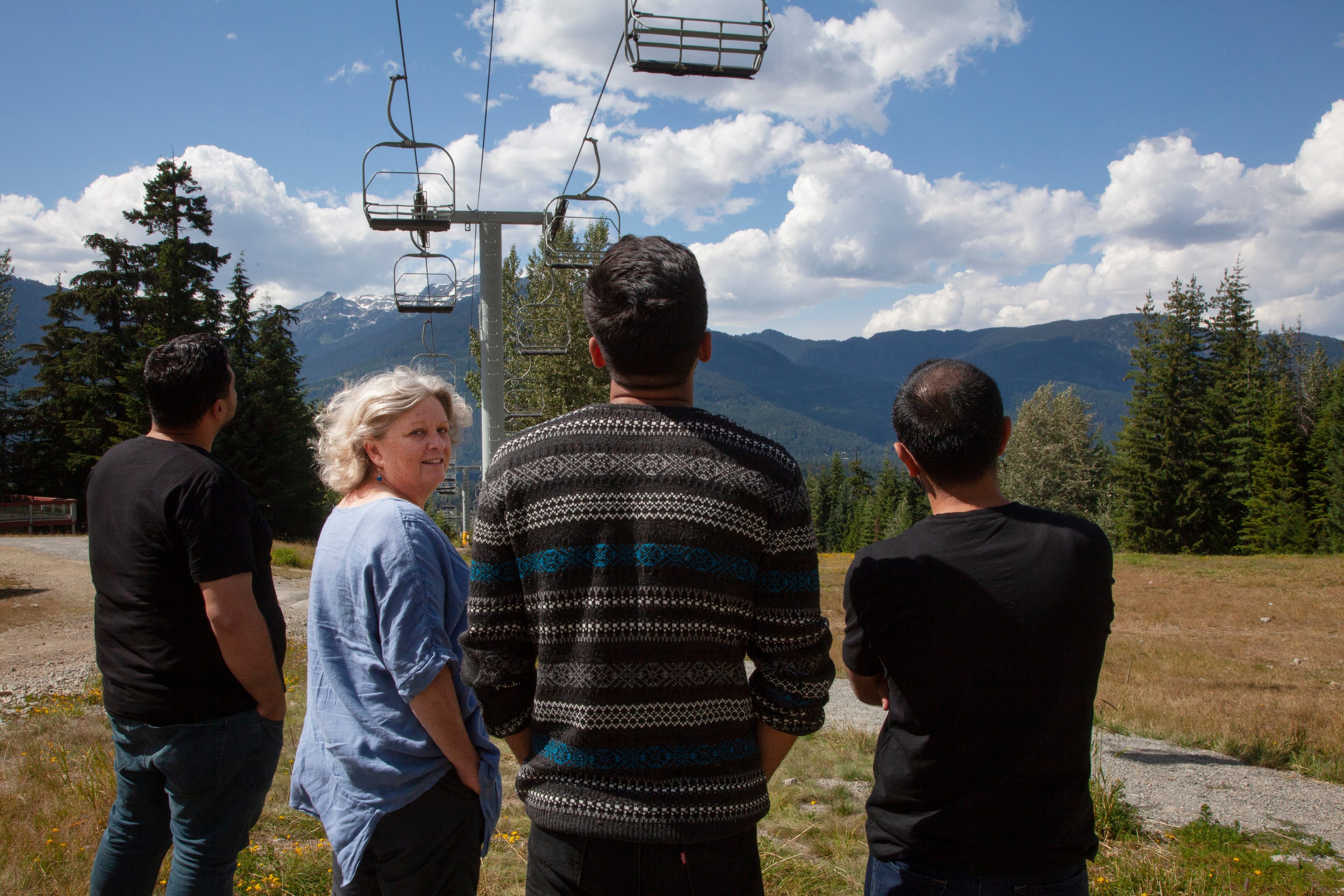 This is Laurie Cooper. She lives in Whistler and has sponsored a number of refugees. She stands in the pictures with three men, two of who are from Syria, and one who is from Afghanistan via Pakistan and Turkey. Two of these three men wish to conceal their identity. (Photograph by Jen Osborne)