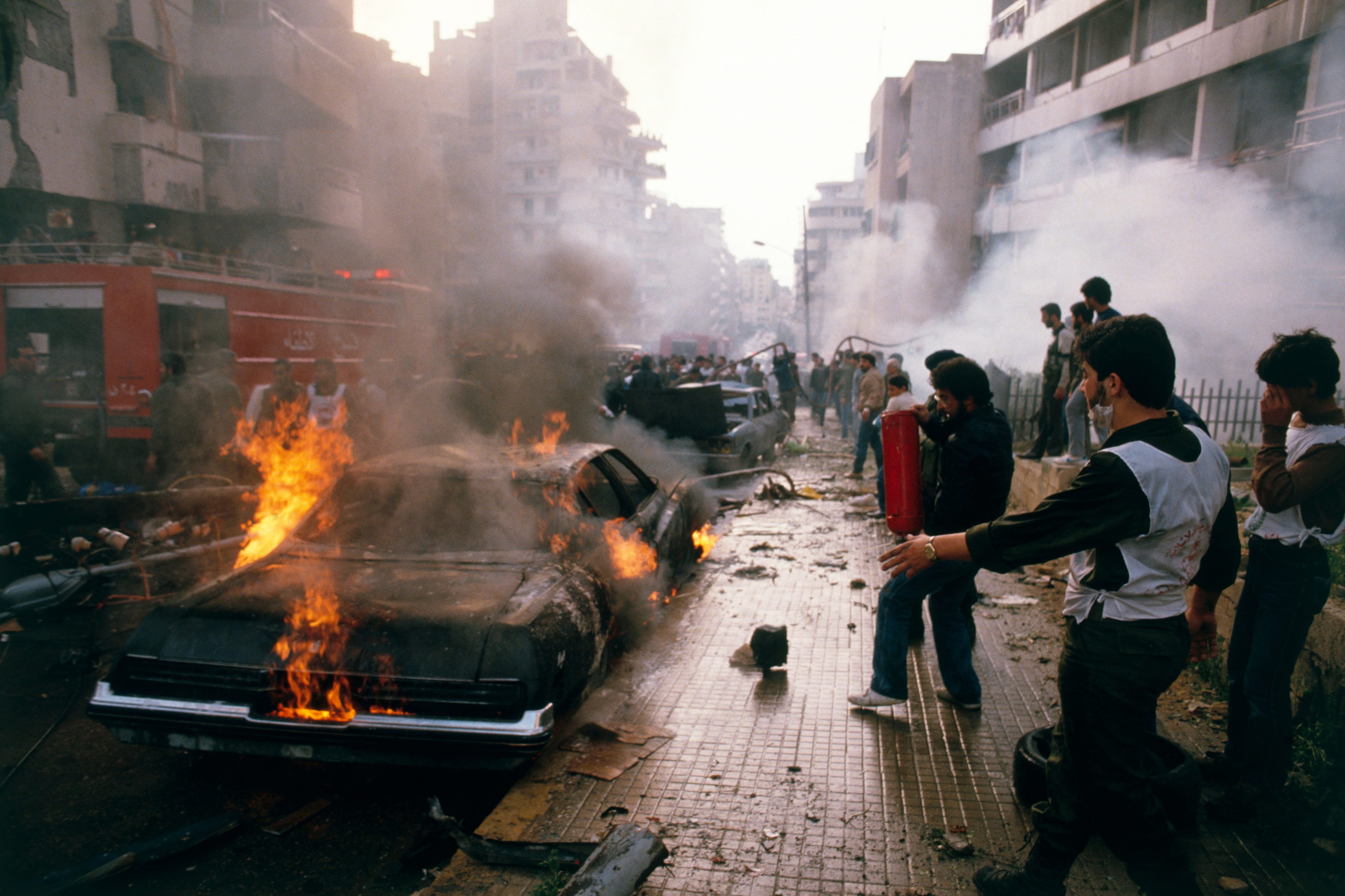 Civil defence volunteers, firemen and passers-by try to help rescue victims and put out fires caused by a massive car bomb, detonated in a main street in West Beirut. (Peter Charlesworth/LightRocket/Getty Images)