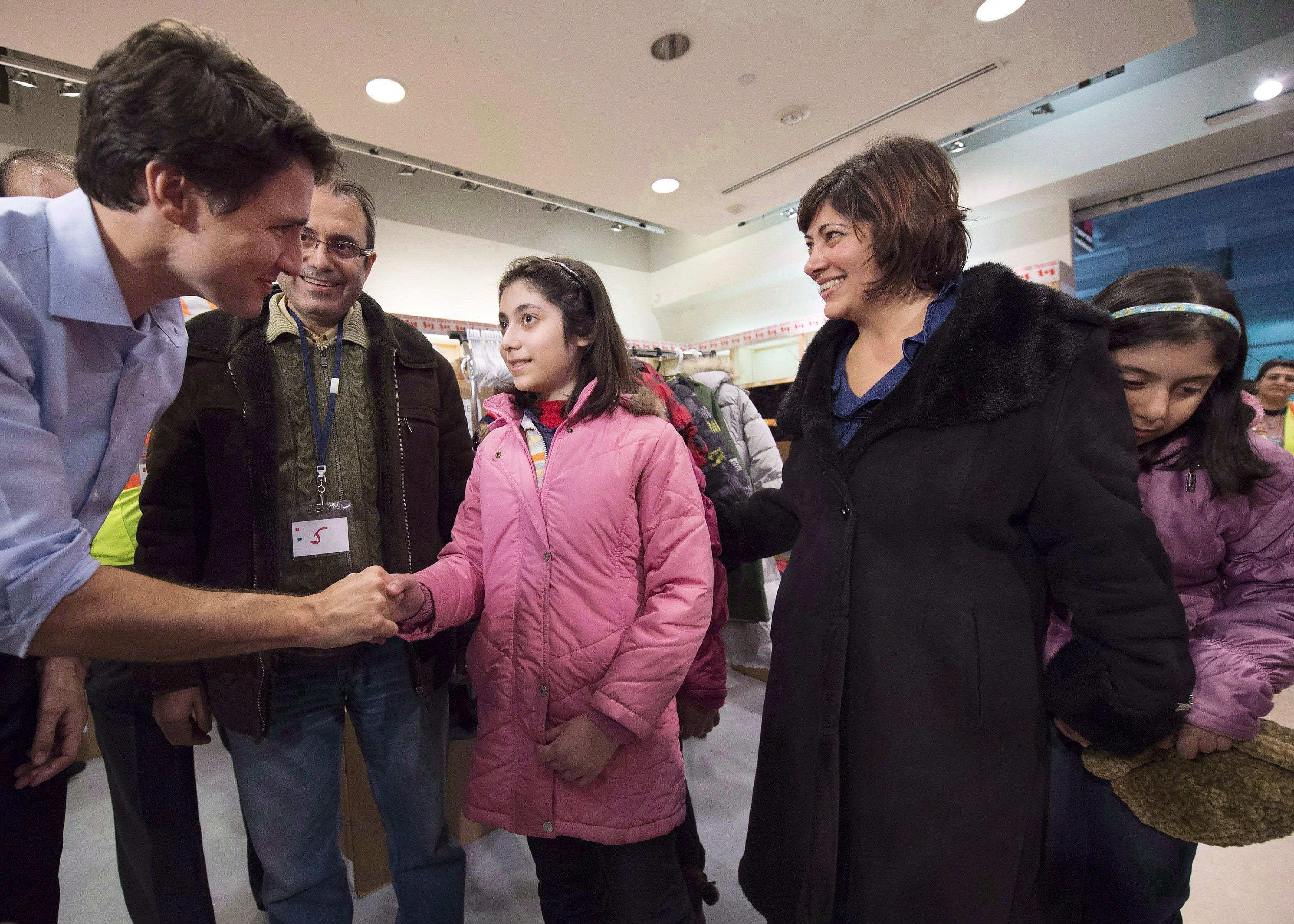 Canadian Prime Minister Justin Trudeau greets newly-arrived Syrian refugees Lucie Garabedian, centre, her father Vanig Garabedian, second left, mother Anjilik Jaghlassian, second right, and sister Anna-Maria Garabedian, right, at Pearson International airport, in Toronto, in a December 11, 2015, file photo. THE CANADIAN PRESS/Nathan Denette
